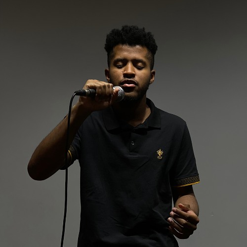 Aluno cantando ao microfone em ensaio na escola